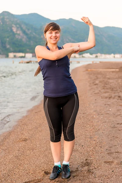 Joven atleta chica sonriendo por el mar —  Fotos de Stock