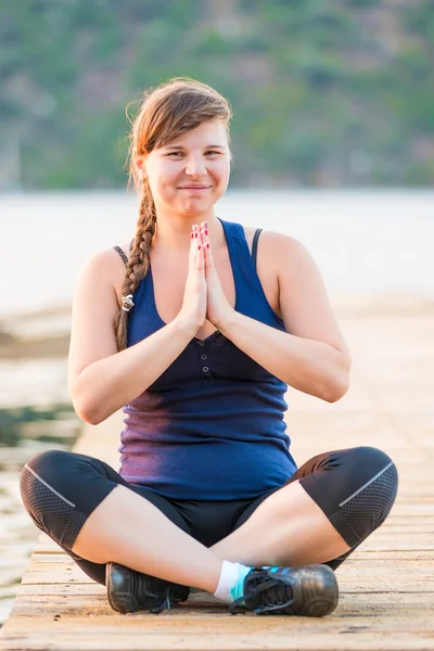 Dívka v lotus pose směje, portrét za svítání — Stock fotografie