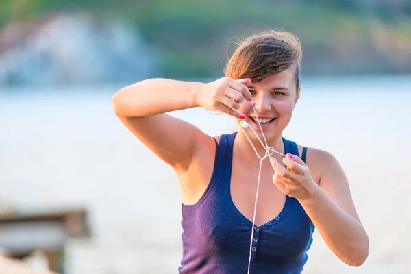 笑顔の若い女性は、ヘッドフォンを解く — ストック写真