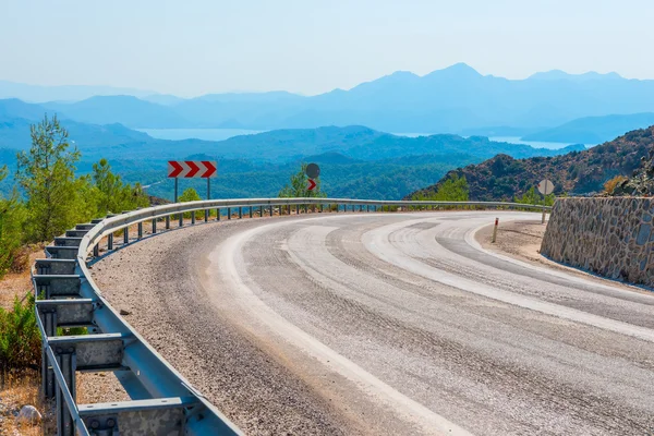 Girare una strada di montagna e una splendida vista sulla distanza — Foto Stock