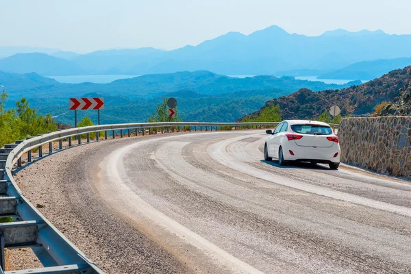 Coche blanco a su vez un camino de montaña — Foto de Stock