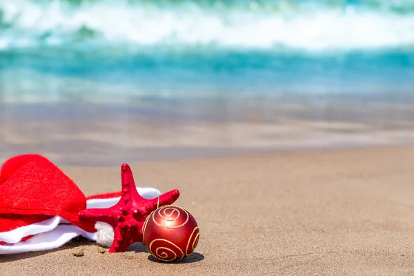 Santa Claus hat on the sand near the sea — Stock Photo, Image