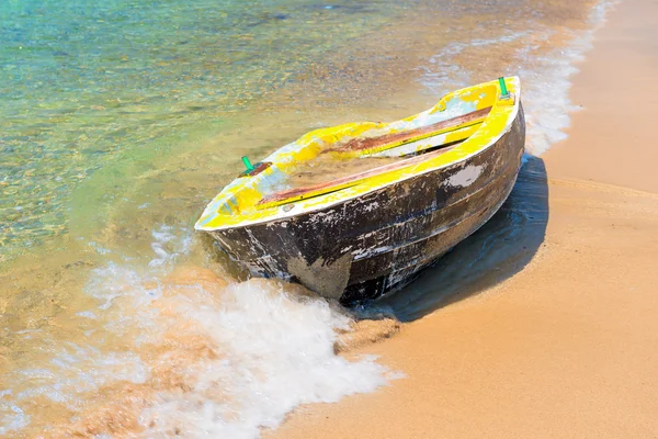 Altes Boot auf einem Sandstrand und einer Meereswelle — Stockfoto