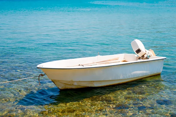 Barco de motor blanco atado a la orilla —  Fotos de Stock