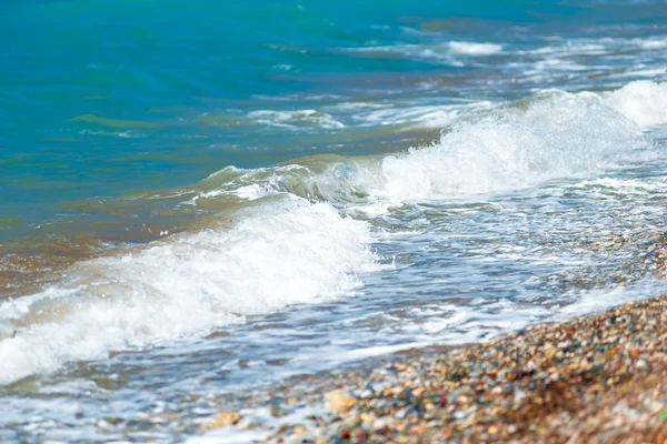 Kiezelstrand en kleine golven van de Egeïsche zee — Stockfoto