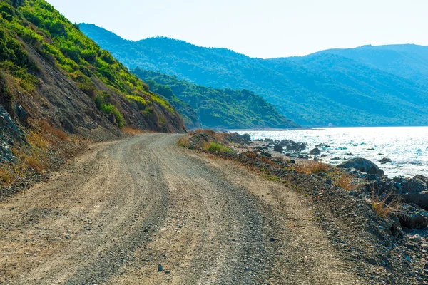 Estrada não pavimentada corre ao longo do mar — Fotografia de Stock