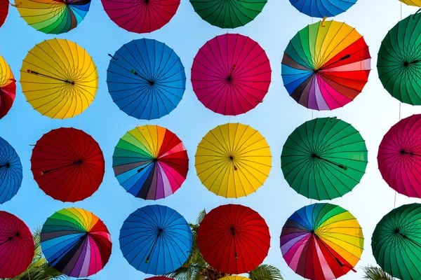 Bunte Regenschirme offenbarten Reihen auf Himmelshintergrund — Stockfoto
