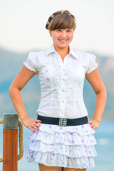 Playful young girl in a white dress on the pier — Stock Photo, Image