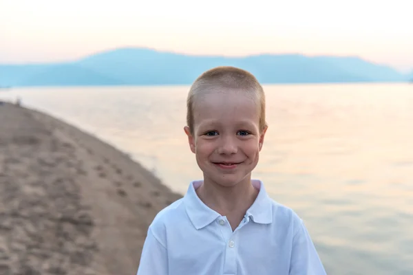 Portrait of a little boy on the beach at sunrise — Stock Photo, Image