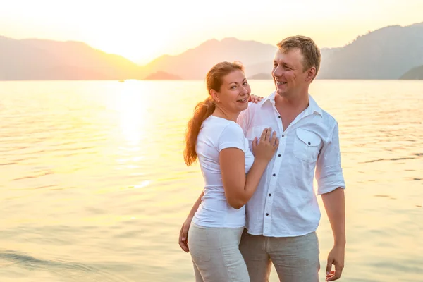 Glückliche Frischvermählte, die sich am Meer umarmen — Stockfoto