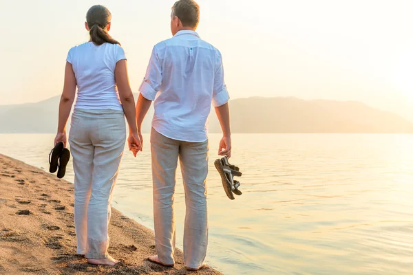 Paar mit den Schuhen in der Hand am Meer — Stockfoto