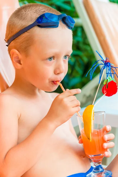 Jongen op een ligstoel naast het zwembad met cocktails — Stockfoto