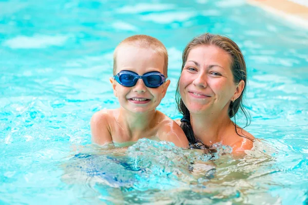 Vrouw met haar zoon in het zwembad zwemmen — Stockfoto