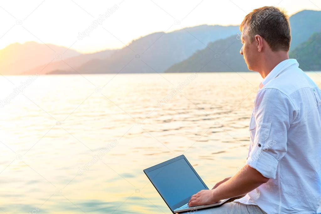 free man with a laptop admires dawn