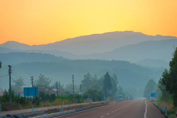 Morning view of the road and the mountains — Stok fotoğraf