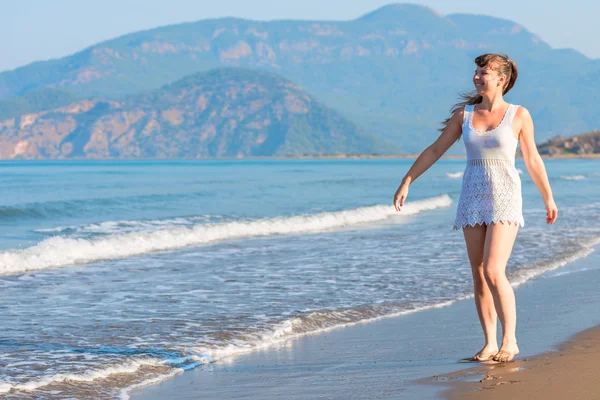 Happy girl walking barefoot on the beach — Stockfoto