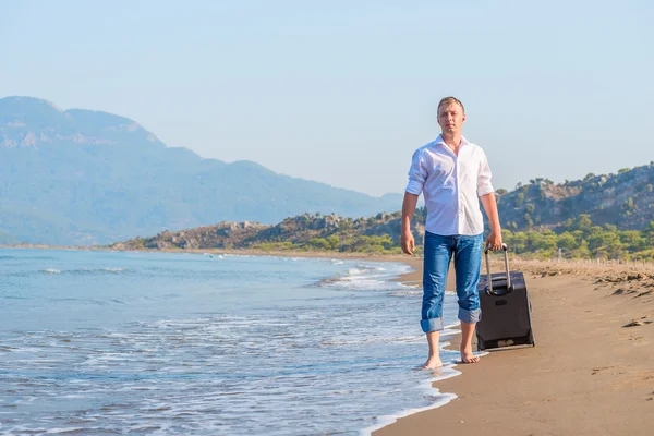 Stroll along the sandy beach with luggage — Stok fotoğraf