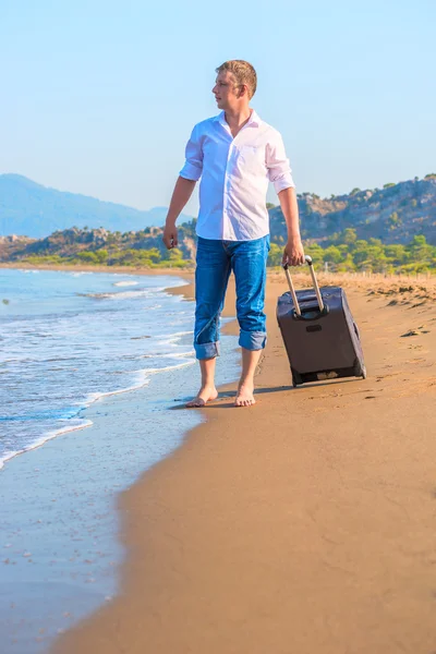 Verlorener Reisender mit Koffer blickt aufs Meer — Stockfoto