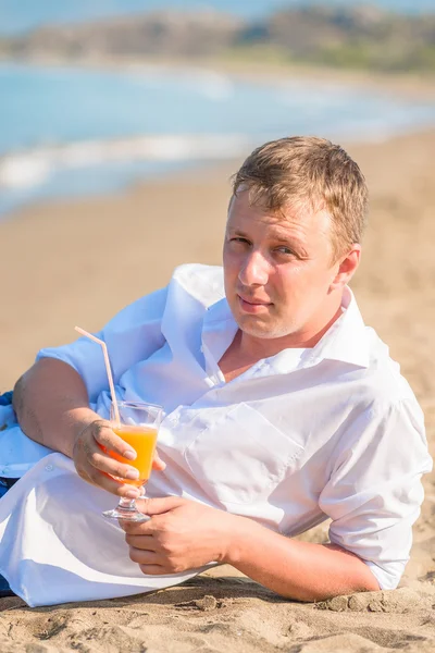 Porträt eines jungen, gut aussehenden Mannes mit einem Glas Cocktail — Stockfoto