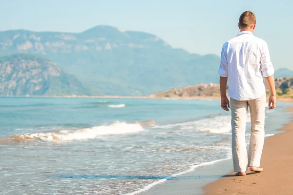 Male walking barefoot on the beach at the resort — Stock Photo, Image