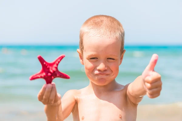 Contentes menino no mar com uma estrela — Fotografia de Stock