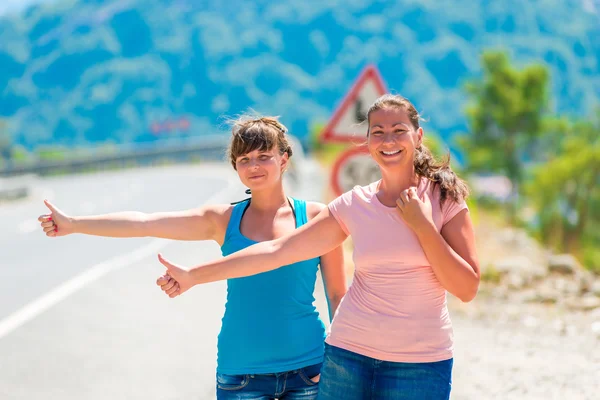 Beautiful young girlfriends stopped passing car — Stock Photo, Image