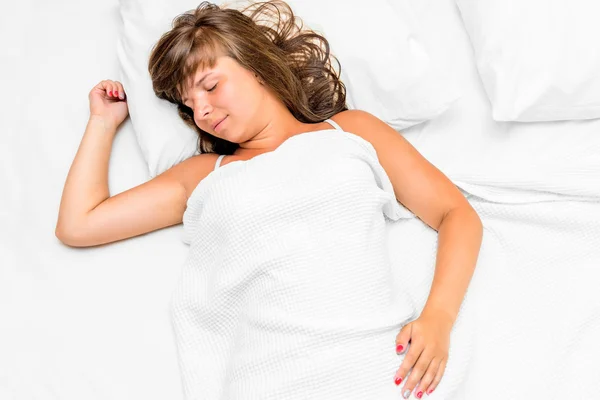 Young beautiful brunette in a bed sleeping sweetly — Stock Photo, Image