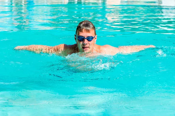 Atleta masculino nadando mariposa golpe en una piscina —  Fotos de Stock