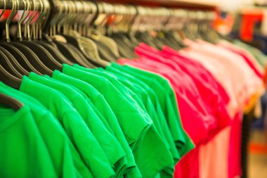 rows of cotton T-shirts in a large store clipart