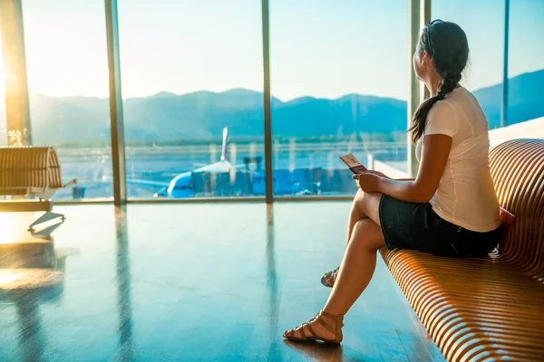 Frau am Flughafen mit einem Ticket, das auf die Abfahrt wartet — Stockfoto