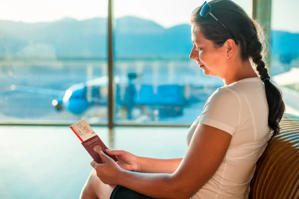 Chica joven con documentos esperando para abordar el avión — Foto de Stock