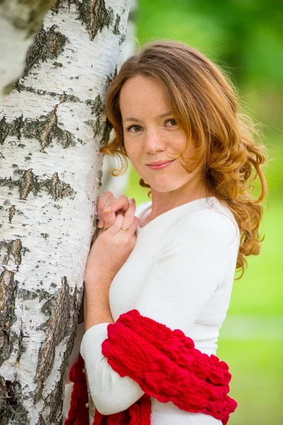 Mooi meisje met rode haren in een berk — Stockfoto
