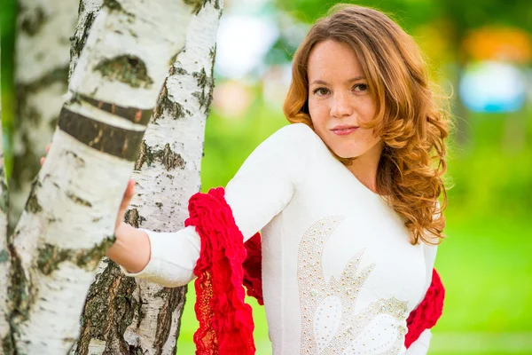 Red-haired girl in a white dress near a birch — Stock Photo, Image