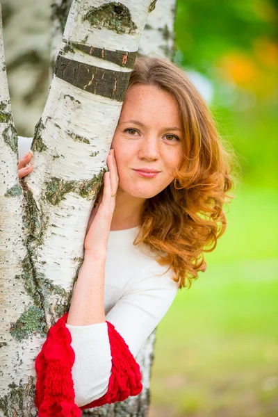 Douce jeune fille embrasse un tronc de bouleau — Photo