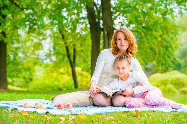 Beautiful mother and daughter spend a weekend at a picnic in the — Stock Photo, Image