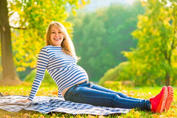 Jonge zwangere moeder comfortabel rusten in het park — Stockfoto