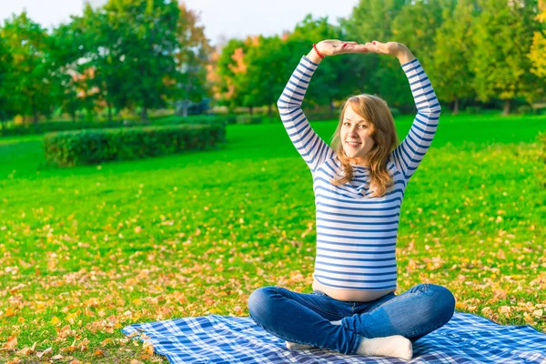 Беременная женщина делает фитнес на открытом воздухе в парке — стоковое фото