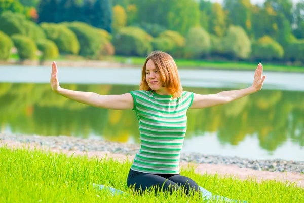 Young athlete warming up near the lake in the park — Stock Photo, Image