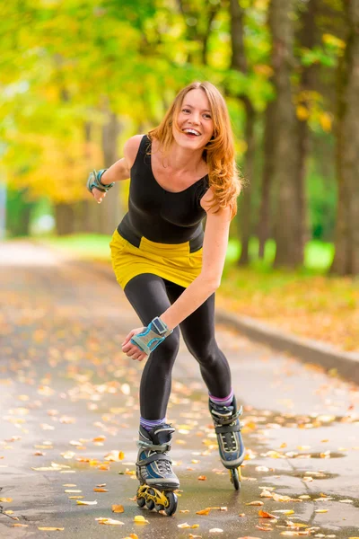 Niña riendo patinaje sobre ruedas en el parque de otoño uno —  Fotos de Stock