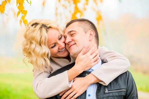 Blonde embraces her lover outdoors in autumn park — Stock Photo, Image