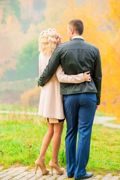 Jovem casal abraçando no parque de outono — Fotografia de Stock