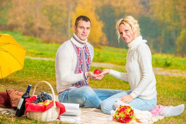 Homem e mulher segurar em suas mãos uma maçã vermelha — Fotografia de Stock