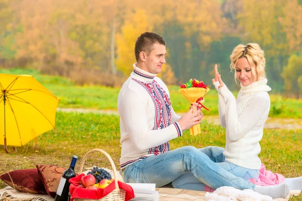 Mężczyzna 35 lat, przedstawia bukiet ukochanej na pikniku — Zdjęcie stockowe
