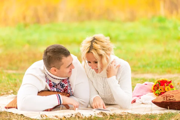 Paar beim gemeinsamen Picknick beim Lesen eines Romans — Stockfoto