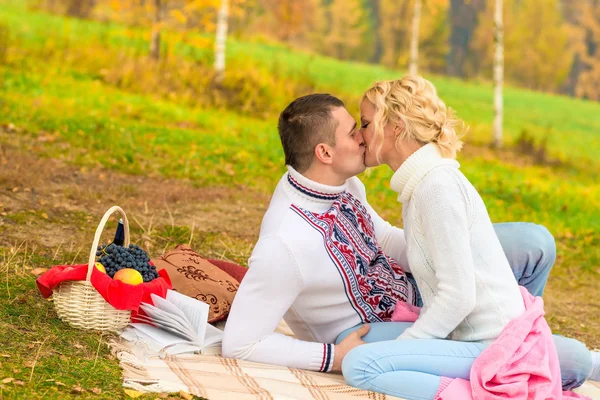 Junges verliebtes Paar küsst sich bei einem Picknick auf einer Decke — Stockfoto