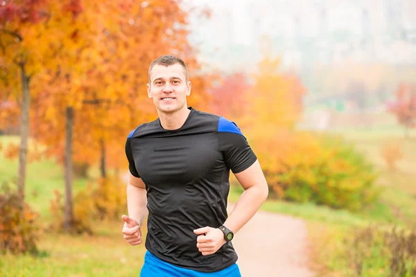 Uomo muscoloso che corre su un sentiero nel parco — Foto Stock