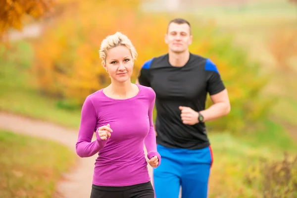 Donna e uomo nel parco autunnale su jogging mattina — Foto Stock