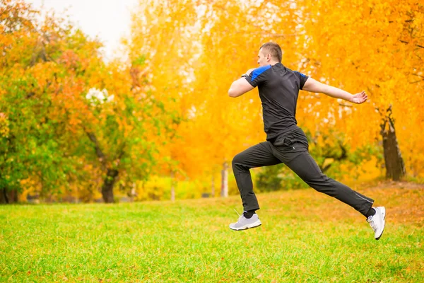 Uomo in abbigliamento sportivo salta in alto durante l'esercizio — Foto Stock