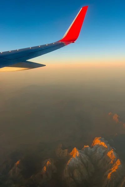 Ala aerei contro il cielo sopra le montagne — Foto Stock