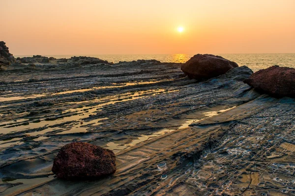 Beautiful sunset over the sea and rocky — Stock Photo, Image